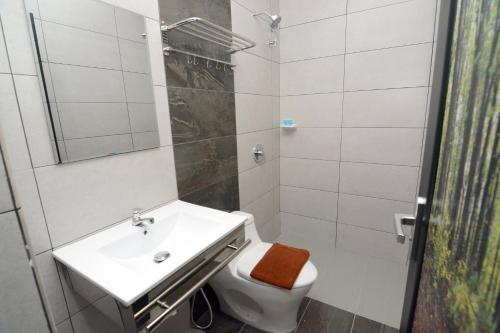 y baño con lavabo, aseo y ducha. en Eco Garden Hotel, en Rawang