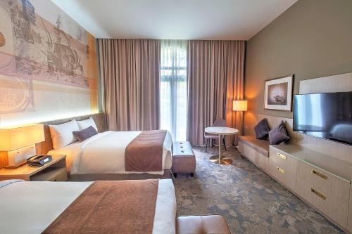 a hotel room with two beds and a flat screen tv at LeoPalace Resort Guam in Yona