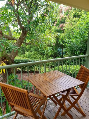 a wooden table and two chairs on a porch at Camelot Boutique Accommodation in Mount Tamborine