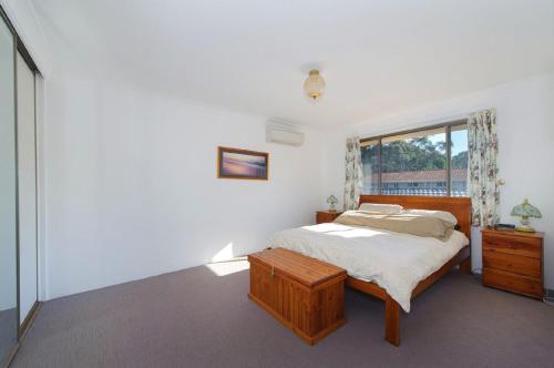 a white bedroom with a bed and a window at Shelly Cove 13 113 Pacific Drive in Port Macquarie