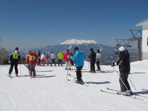 a group of people on skis on a ski slope at Ryokan Yamakanoyu in Kiso