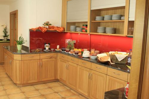 a kitchen with wooden cabinets and a red wall at Gasthof Sempt in Spörerau