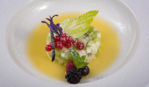 a plate of food with fruit on a yellow sauce at Shalai - Exclusive SPA and small gourmet hotel in Linguaglossa