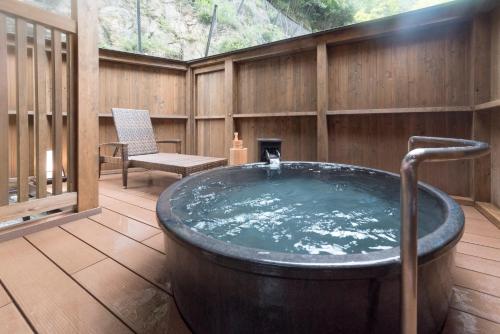 a large bath tub sitting on a wooden deck at Yunotani Senkei in Totsukawa