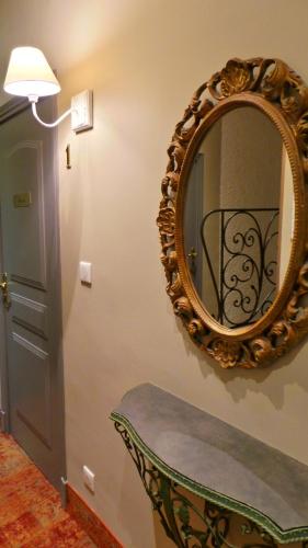 a mirror on a wall with a bench and a door at Hotel Relais Du Postillon in Antibes