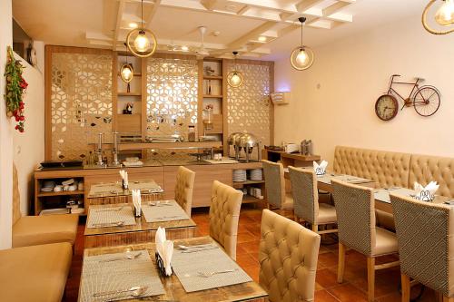 a restaurant with tables and chairs and a counter at Ahuja Residency Parklane, Gurgaon in Gurgaon