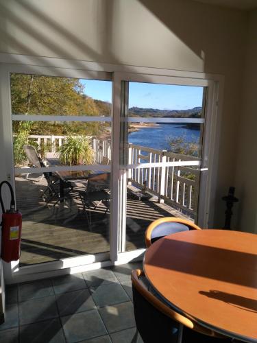 a patio with a table and a view of a lake at Hôtel du Lac in Treignac