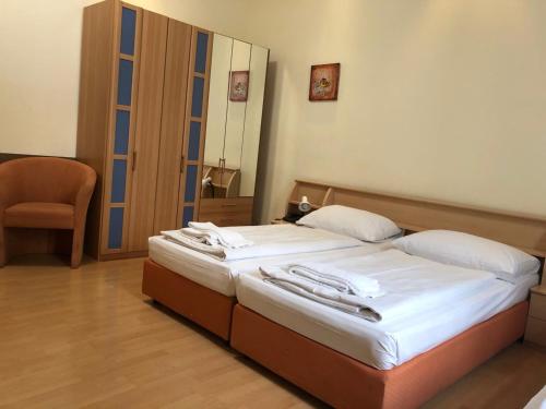 a bedroom with a bed with white sheets and a mirror at Pension Vera in Vienna
