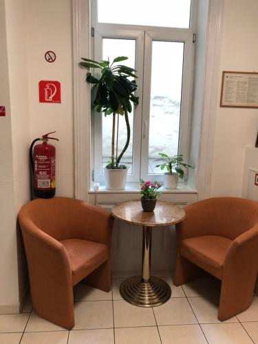a room with two chairs and a table and a window at Pension Vera in Vienna