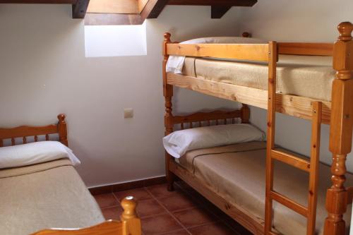 a room with two bunk beds and a bed at Albergue Cabrales in Carreña de Cabrales