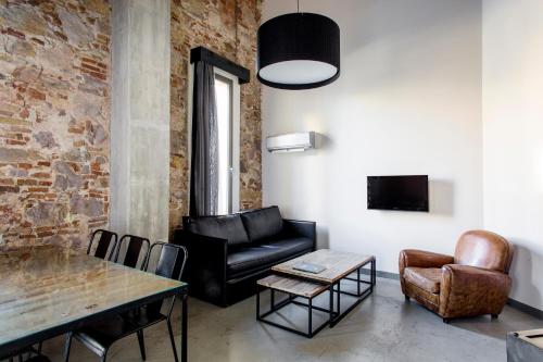 バルセロナにあるバルセロナ アパートメント レプブリカのリビングルーム(黒い革張りのソファ、テーブル付)