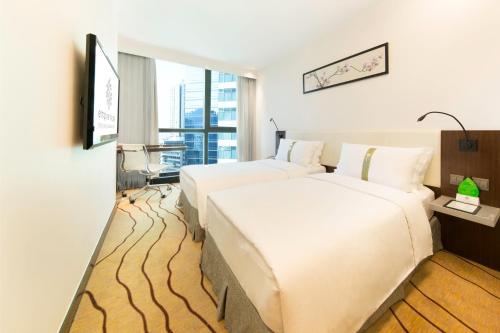 a hotel room with two beds and a window at Empire Hotel Causeway Bay in Hong Kong