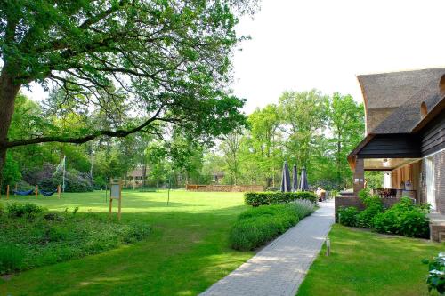 a house with a garden with a park in the background at Landgoedhotel Woodbrooke Barchem in Barchem