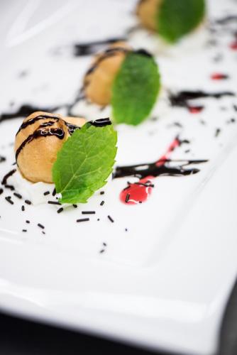a plate of food with a green leaf on it at Hotel Enzian Genziana in Siusi