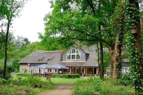 a large house with a gambrel roof at Landgoedhotel Woodbrooke Barchem in Barchem