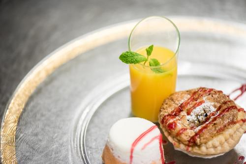 a plate with a pastry and a glass of orange juice at Hotel Enzian Genziana in Siusi