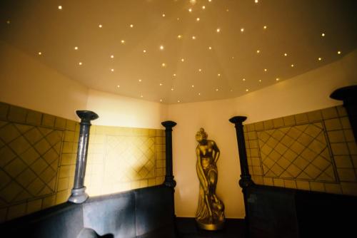 a room with a ceiling with lights and a statue at Hotel Enzian Genziana in Siusi