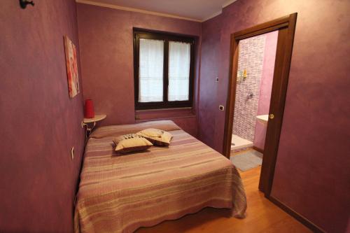 a bedroom with a bed in a room with purple walls at B&B Villa Anita in Bellano