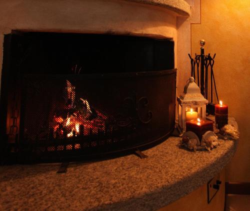a fireplace with two lit candles and two lit candles at B&B Villa Anita in Bellano