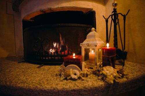 a fireplace with two candles in front of a stove at B&B Villa Anita in Bellano