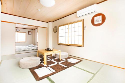 een woonkamer met een tafel en een bed bij Shirakabanoyado - Kujo in Osaka