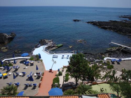 a view of a resort with a pool and the ocean at Hotel Nike in Giardini Naxos