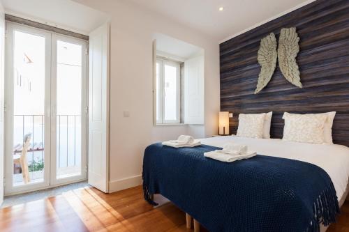 リスボンにあるSao Bento Blue One-Bedroom Apartment - by LU Holidaysのベッドルーム1室(大型ベッド1台、青い毛布付)