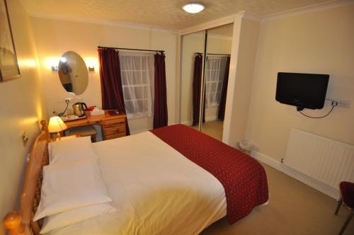a hotel room with a bed and a television at The Roundabout Hotel in Fareham