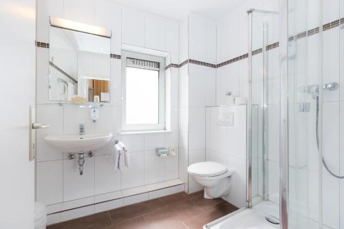 a bathroom with a toilet and a sink and a shower at Hotel Fürst Bismarck in Hamburg