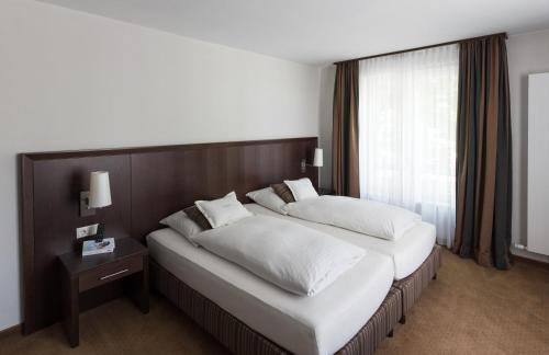 a hotel room with two beds and a window at Restaurant & Hotel Engelkeller in Memmingen