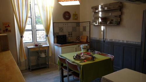 une cuisine avec une table et un tissu de table vert dans l'établissement Appartements Ria Sirach, à Ria