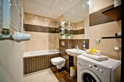a bathroom with a washing machine and a sink at Villa Aqua BlueApart Jurata in Jurata