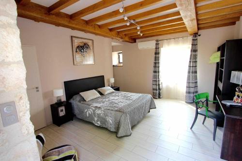 une chambre avec un lit, une table et une fenêtre dans l'établissement Aux Vents d'anges, à Cahuzac-sur-Vère