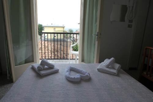 un letto con tre asciugamani sopra di Hotel Diamante 5 minuti dalla fiera di rimini CON PARCHEGGIO INCLUSO a Rimini