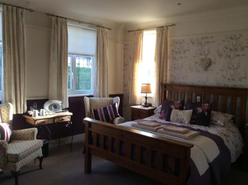 a bedroom with a bed and a chair at Ashbourne House in Sheringham
