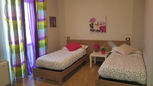 two beds in a room with colorful curtains at Antico Casale in Turin
