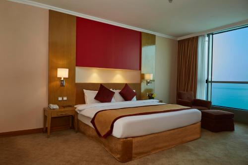 a hotel room with a bed and a large window at Kuwait Grand Hotel in Kuwait