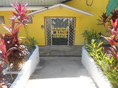 a yellow house with a door and some plants at Banana Bay Marina in Golfito