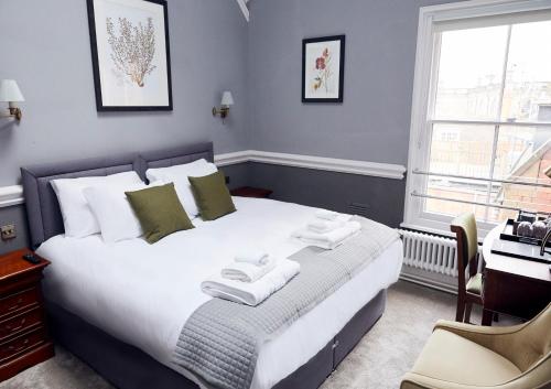 a bedroom with a large bed with towels on it at The Old Coffee Tavern in Warwick