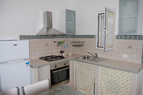 a kitchen with a sink and a stove top oven at Villa Marianna in Ostuni