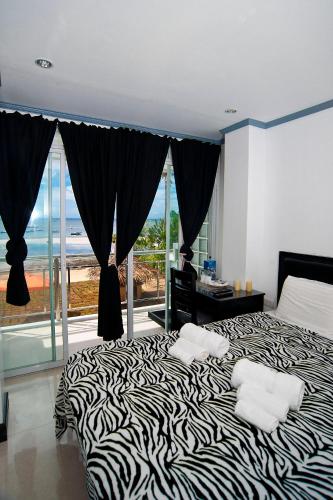 a bedroom with a zebra print bed with a view of the ocean at Bohol South Beach Hotel in Panglao