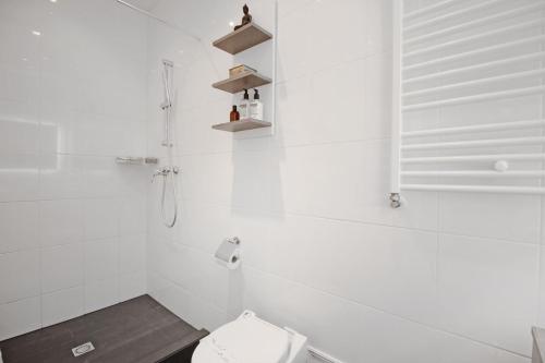 a white bathroom with a toilet and a shower at New monumental garden view Studio in Amsterdam