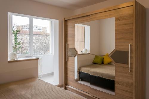 Habitación pequeña con cama y ventana en Bike-Friendly Apartment, en Timisoara