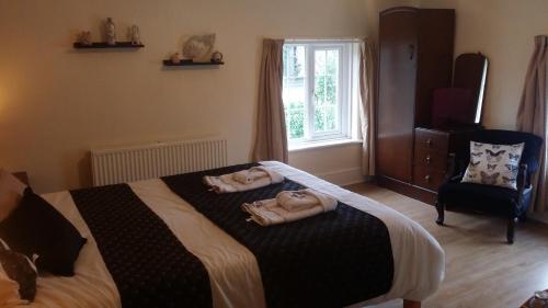 a bedroom with a bed with two towels on it at Kingsmede Bed & Breakfast in Ventnor