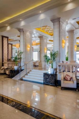 a lobby of a hotel with chairs and a staircase at Boudl Taif in Taif