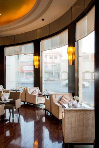 a restaurant with couches and tables and windows at Boudl Taif in Taif