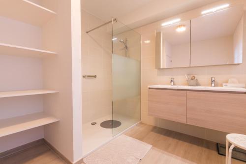 een badkamer met een glazen douche en een wastafel bij Hotel Atlanta Knokke in Knokke-Heist