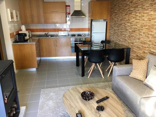 a kitchen and living room with a couch and a table at Desafios da Horta in Souto da Velha