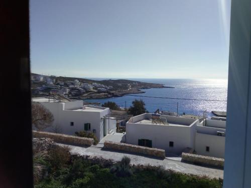 a view of a town with white buildings and the ocean at Asterias House in Donoussa