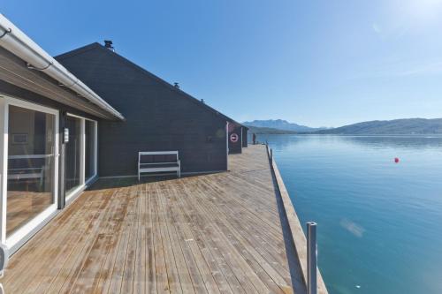 a dock with a house on the water at Finsnes Gaard in Finnsnes